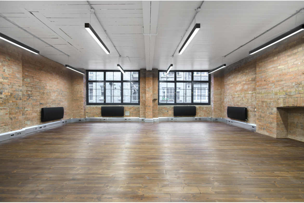 Refurbished office suite with brick walls and wooden floors, commercial property in Soho let by Anton Page